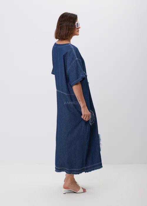 Jeansowa sukienka maxi oversize z krótkim, szerokim rękawem, ozdobiona dekoracyjnymi przeszyciami oraz naszywanymi aplikacjami w kształcie okręgów z postrzępionym wykończeniem. Luźny fason zapewnia wygodę i tworzy nowoczesną, casualową stylizację.