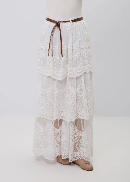 Biała koronkowa spódnica maxi w stylu boho z warstwowymi falbanami, ażurowymi haftami i ozdobnym brązowym paskiem w talii. Romantyczny model o efektownym wykończeniu, idealny do letnich i eleganckich stylizacji.