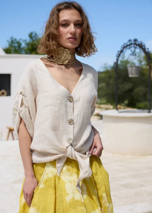 Pleciony dodatek z rafii w naturalnym beżowym odcieniu z dużym kwiatem, który można nosić jako naszyjnik lub pasek. Wielofunkcyjny model w stylu boho efektownie uzupełnia sukienki, tuniki i letnie stylizacje.