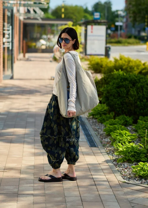 Duża beżowa torba typu shopper z miękkiej tkaniny z ozdobnym chwostem i drewnianymi koralikami.