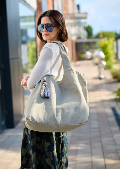 Duża beżowa torba typu shopper z miękkiej tkaniny z ozdobnym chwostem i drewnianymi koralikami.