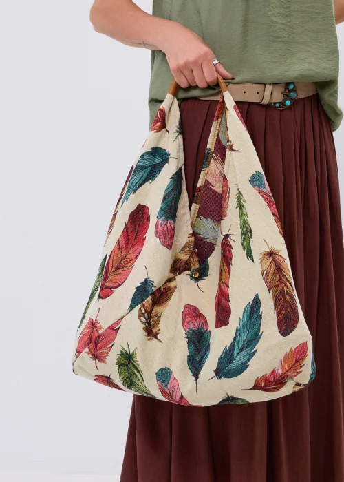 Duża materiałowa torba shopper w kremowym kolorze ozdobiona wielobarwnym wzorem piór. Pojemny model z wygodnymi uchwytami, idealny do codziennych stylizacji, na zakupy, spacer lub wyjazd.