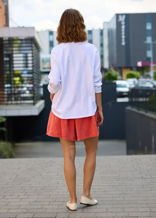 Biała bluzka damska Scarlet Bloom z dekoltem V i haftem kwiatowym przy dekolcie, luźny fason z opuszczoną linią ramion, styl casual.