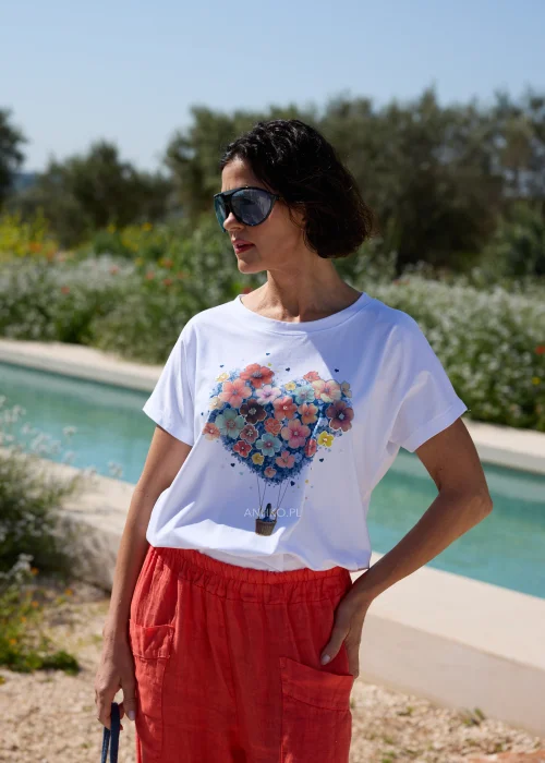 Biały damski T-shirt z kolorowym nadrukiem przedstawiającym serce ułożone z kwiatów unoszone przez balon. Model z krótkim rękawem i okrągłym dekoltem