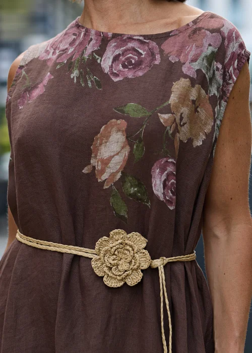 Pleciony dodatek z rafii w naturalnym beżowym odcieniu z dużym kwiatem, który można nosić jako naszyjnik lub pasek. Wielofunkcyjny model w stylu boho efektownie uzupełnia sukienki, tuniki i letnie stylizacje.