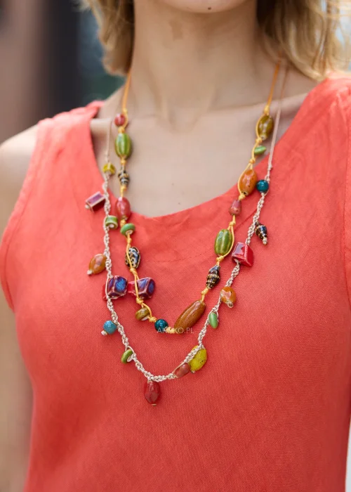 Kolorowy naszyjnik damski z dużymi ceramicznymi koralikami w odcieniach czerwieni, zieleni, turkusu i pomarańczu na plecionych sznurkach w stylu boho.