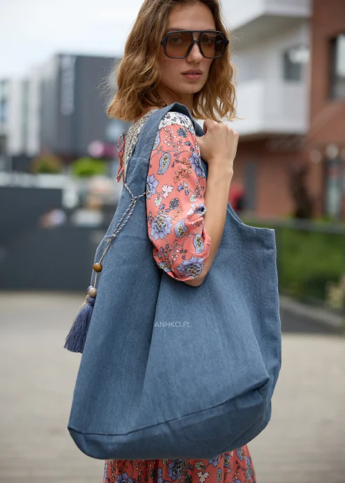 Niebieska torba shopper z miękkiej tkaniny z ozdobnymi chwostami i drewnianymi koralikami.