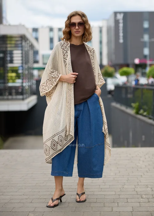 Kimono boho ecru z geometrycznym wzorem w odcieniach beżu. Długi, luźny fason z lekkiej dzianiny tworzy efektowną warstwową stylizację