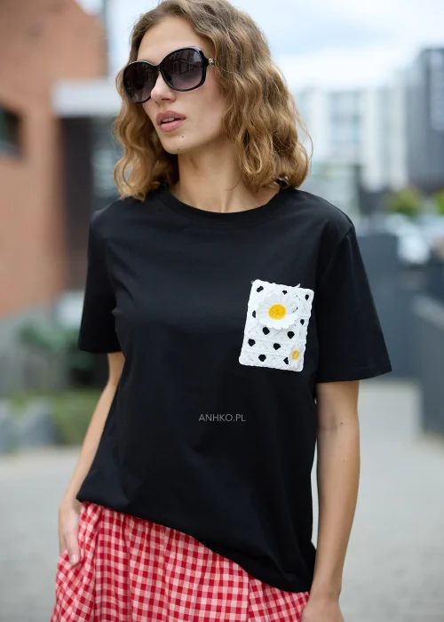 Czarna bluzka t-shirt damski z krótkim rękawem i ozdobną kieszonką z ażurową aplikacją w kształcie stokrotki.