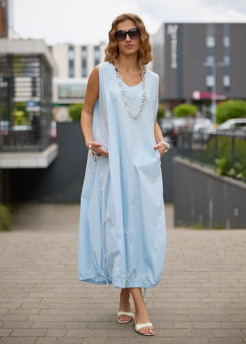 Sukienka maxi w błękitnym kolorze to propozycja dla kobiet, które cenią wygodę i minimalistyczną elegancję. Luźny fason typu bombka swobodnie układa się na sylwetce, a dekolt w kształcie litery V subtelnie podkreśla szyję.