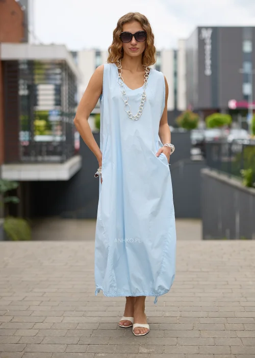 Sukienka maxi w błękitnym kolorze to propozycja dla kobiet, które cenią wygodę i minimalistyczną elegancję. Luźny fason typu bombka swobodnie układa się na sylwetce, a dekolt w kształcie litery V subtelnie podkreśla szyję.