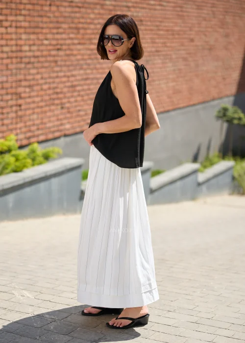 Biała spódnica maxi z delikatnymi pionowymi prążkami i elastyczną talią, zwiewny fason w minimalistycznej eleganckiej stylizacji.
