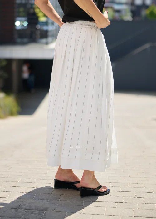 Biała spódnica maxi z delikatnymi pionowymi prążkami i elastyczną talią, zwiewny fason w minimalistycznej eleganckiej stylizacji.
