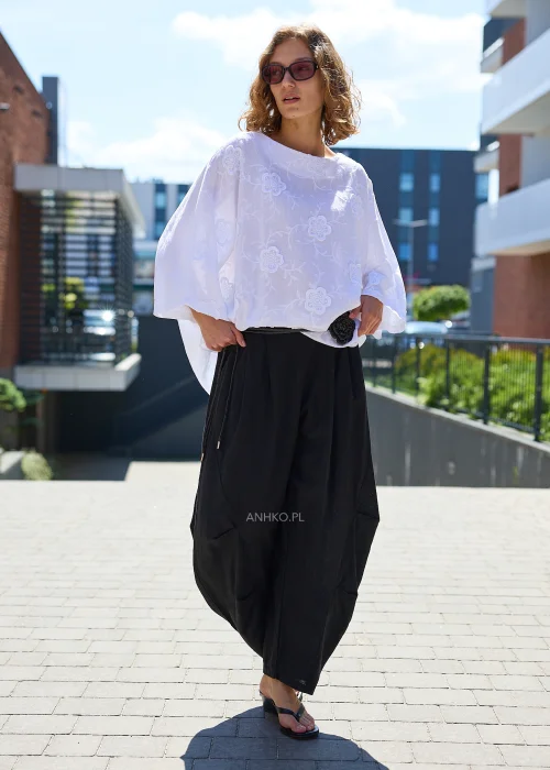 Czarne damskie spodnie typu haremki z szerokimi nogawkami, wysokim stanem i ozdobnymi zakładkami.