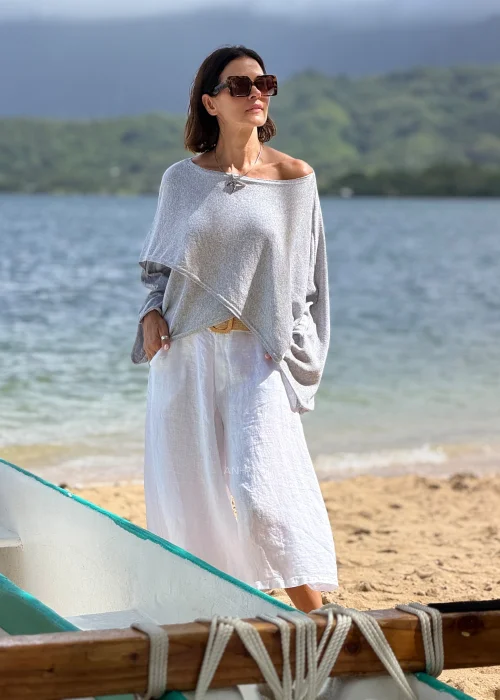 Damska bluzka oversize jasnoszara z szerokim dekoltem i długimi rękawami, luźny asymetryczny fason w stylu casual.