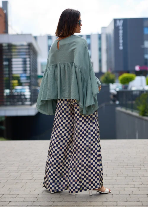 Miętowa damska bluzka oversize z szerokimi rękawami typu kimono i marszczonym odcięciem pod biustem.