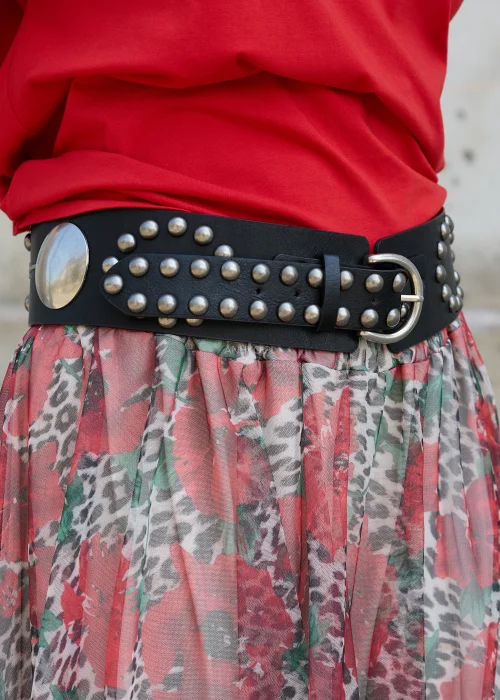 Czarny szeroki pasek damski z dużymi srebrnymi aplikacjami, metalowymi nitami oraz klasyczną klamrą z bolcem. Wyrazisty model inspirowany stylem rockowym i western.