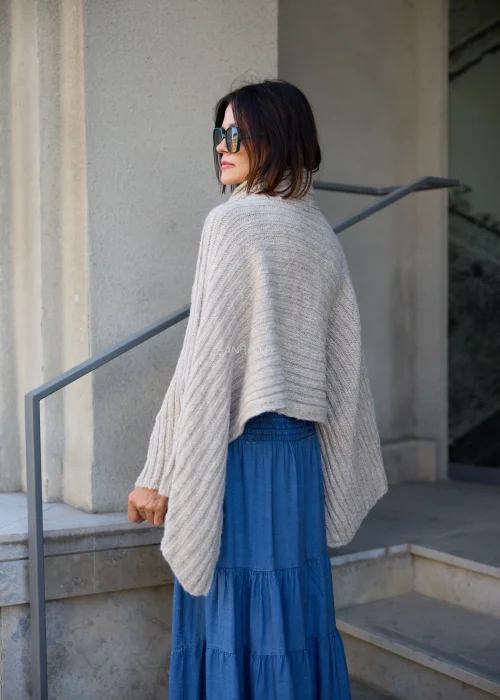 Beżowe sweter-ponczo w odcieniu taupe o miękkim, otulającym splocie i oversize’owym fasonie. Ciepły model z szerokim kołnierzem, idealny do warstwowych stylizacji w stylu boho i casual chic.