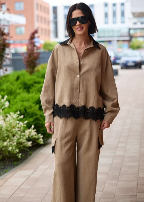 Koszula oversize w kolorze brązowym z czarną koronką przy kołnierzu i dole, o luźnym kroju z długim rękawem.