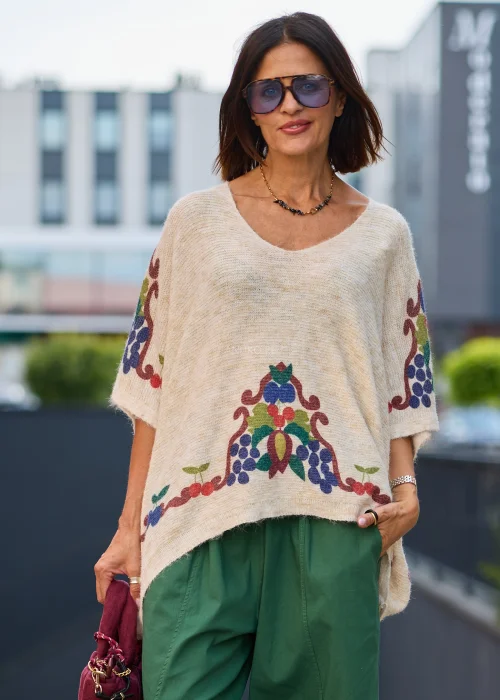 Beżowy sweter damski oversize z krótkim rękawem, dekoltem V i kolorowym wzorem roślinnym
