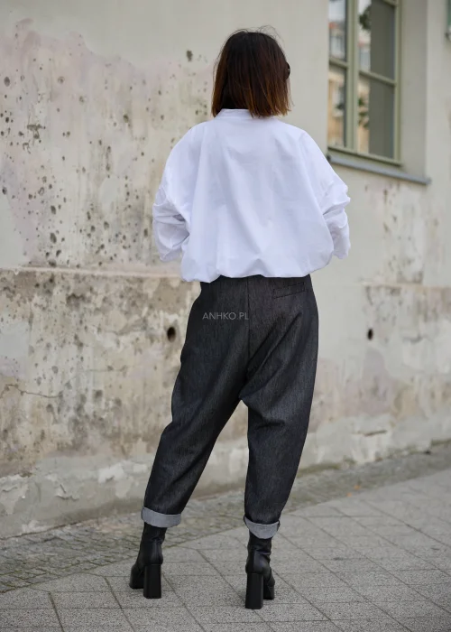 Spodnie damskie o luźnym fasonie z obniżonym krokiem, w grafitowym odcieniu denimu, ze zwężanymi nogawkami i wywiniętymi mankietami.