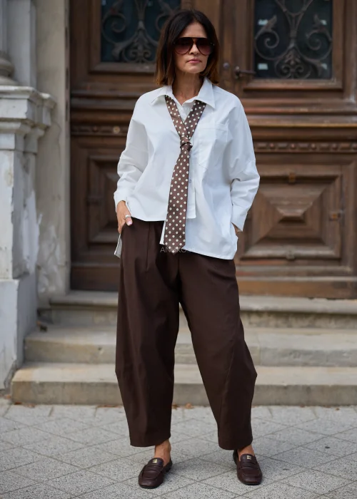 Krawat Laurito w czekoladowym brązie z dużymi beżowymi grochami i klasycznym szpicem. Elegancki detal o retro charakterze do koszuli i marynarki.