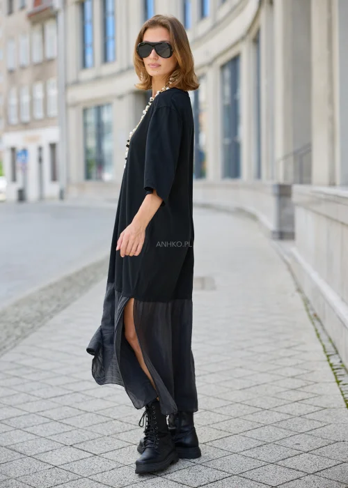 Czarna sukienka damska maxi o luźnym fasonie oversize, z rękawami 3/4 i kontrastowym, lekko transparentnym dołem z lekkiej tkaniny.