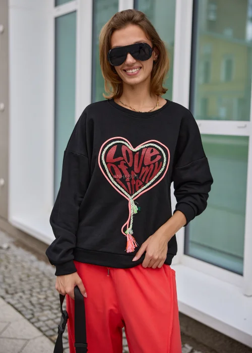 Bluza damska w czarnym kolorze, o luźnym fasonie oversize z długimi rękawami i dekoracyjnym motywem serca z napisem oraz kolorowymi sznurkami.