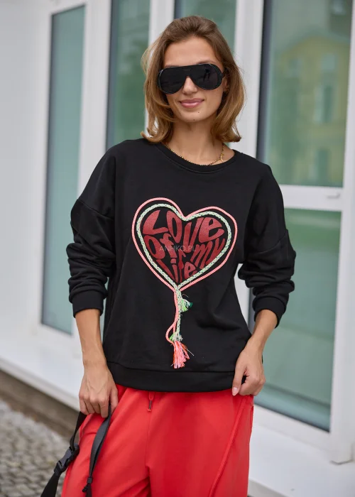 Bluza damska w czarnym kolorze, o luźnym fasonie oversize z długimi rękawami i dekoracyjnym motywem serca z napisem oraz kolorowymi sznurkami.