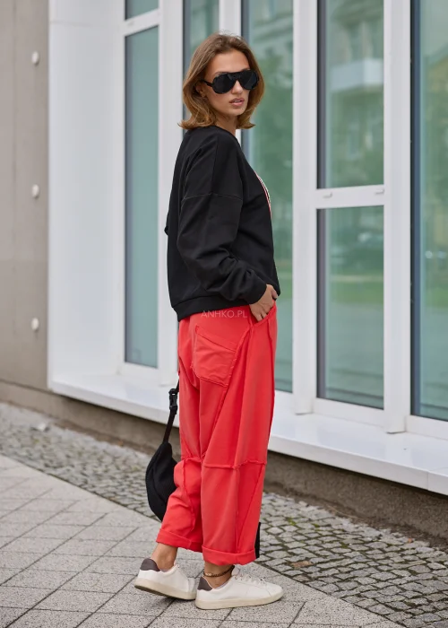 Bluza damska w czarnym kolorze, o luźnym fasonie oversize z długimi rękawami i dekoracyjnym motywem serca z napisem oraz kolorowymi sznurkami.