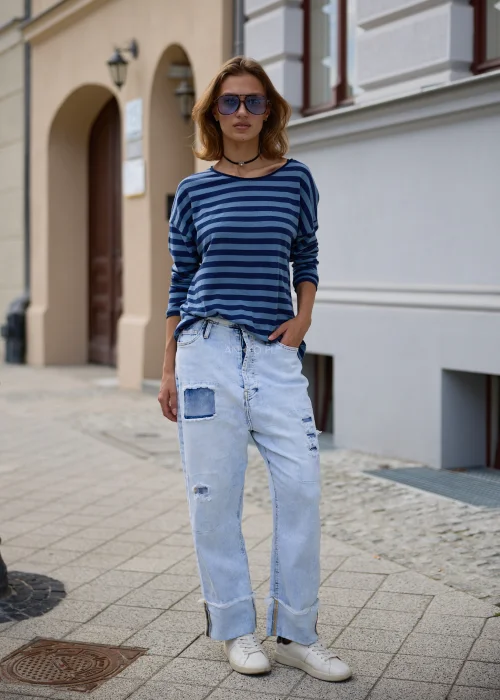 Bluzka damska oversize w granatowo-niebieskie paski, z szerokim okrągłym dekoltem, obniżoną linią ramion i długimi rękawami.