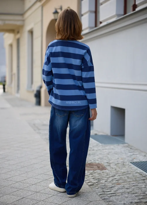 Bluzka damska oversize w szerokie jasnoniebiesko-granatowe pasy, z dekoltem V, obniżoną linią ramion i długimi rękawami.