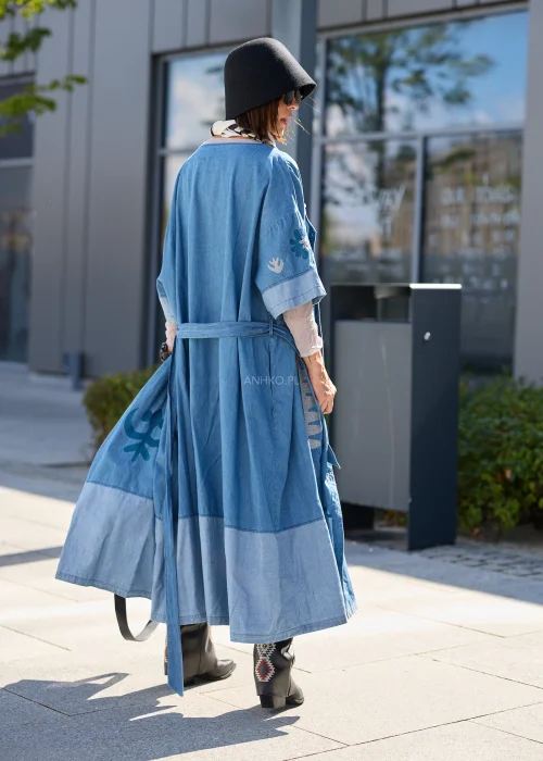 Jeansowa sukienka maxi w odcieniu niebieskiego denimu z haftowanymi wzorami, wiązana w talii paskiem, zapinana na guziki, o luźnym fasonie z szerokimi rękawami