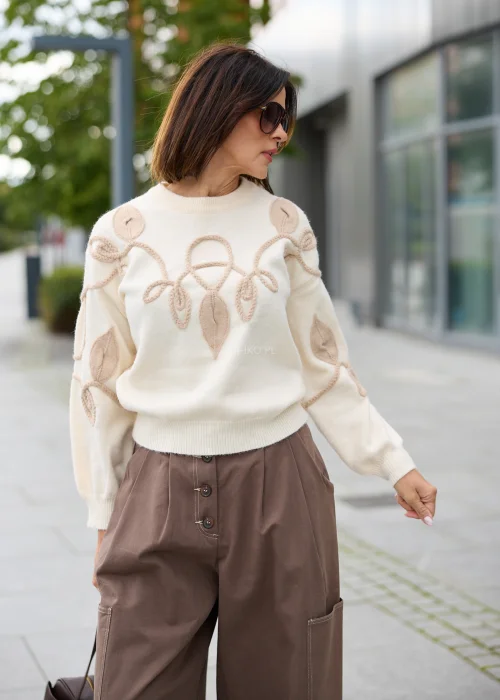 Sweter damski w kolorze ecru, z okrągłym dekoltem, długimi rękawami i beżową aplikacją roślinną 3D.