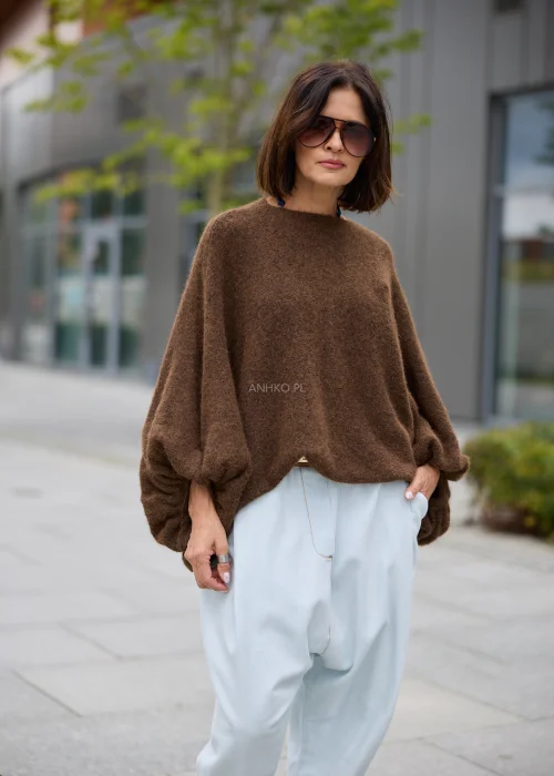Sweter damski oversize w brązowym kolorze, z okrągłym dekoltem i szerokimi, drapowanymi rękawami.