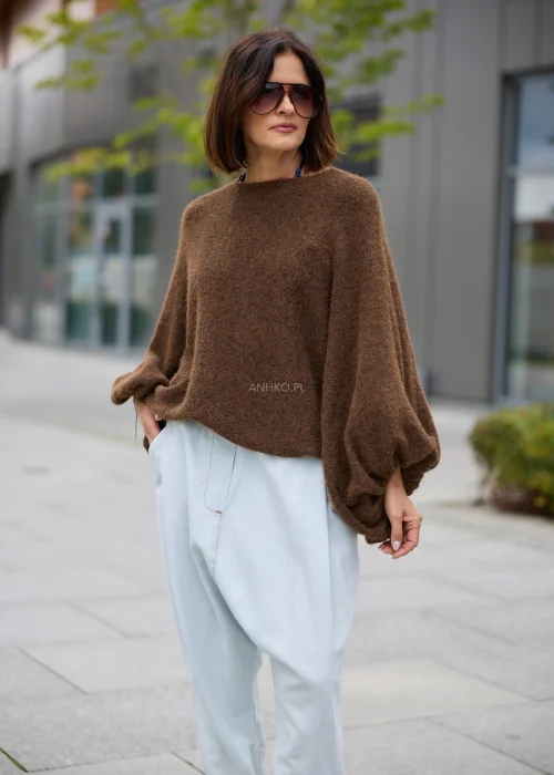 Sweter damski oversize w brązowym kolorze, z okrągłym dekoltem i szerokimi, drapowanymi rękawami.