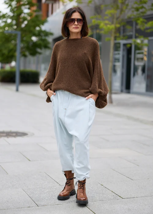 Sweter damski oversize w brązowym kolorze, z okrągłym dekoltem i szerokimi, drapowanymi rękawami.