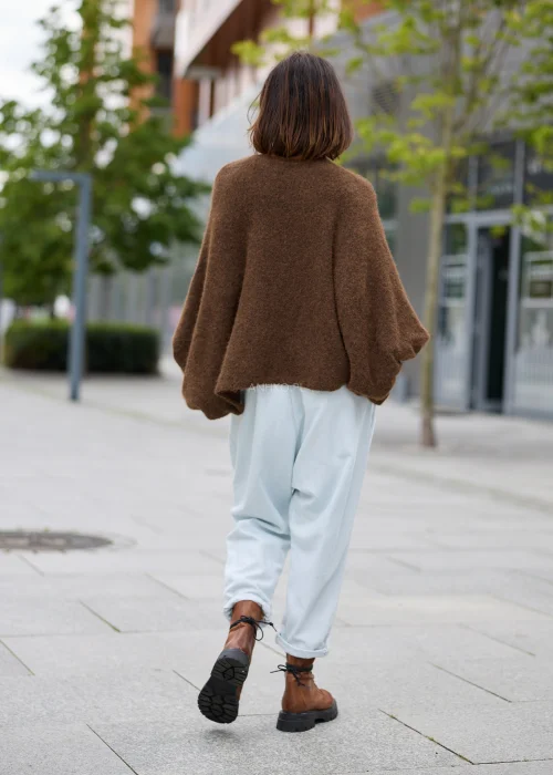Sweter damski oversize w brązowym kolorze, z okrągłym dekoltem i szerokimi, drapowanymi rękawami.