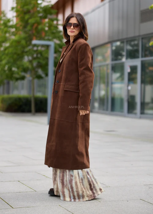 Długi płaszcz damski w brązowym kolorze, o prostym kroju, z klasycznymi klapami, zapięciem na guziki i kieszeniami.