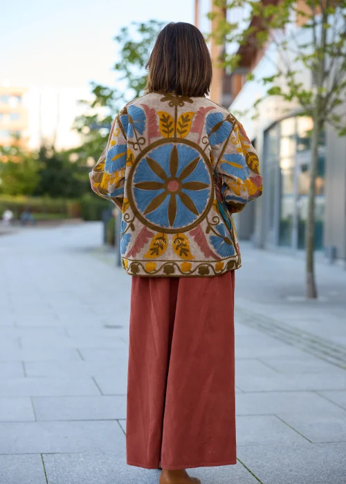 Spódnica sztruksowa maxi w kolorze ceglastym z wysokim stanem i paskiem do wiązania, o rozkloszowanym fasonie, stylizowana z lekką bluzką i botkami w stylu boho.