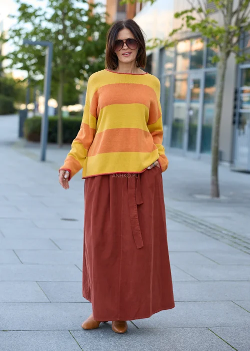 Spódnica sztruksowa maxi w kolorze ceglastym z wysokim stanem i paskiem do wiązania, o rozkloszowanym fasonie, stylizowana z lekką bluzką i botkami w stylu boho.