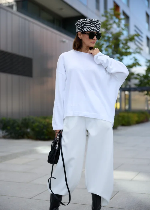 Sweter damski oversize biały z asymetrycznym dekoltem, obniżoną linią ramion i luźnym fasonem.