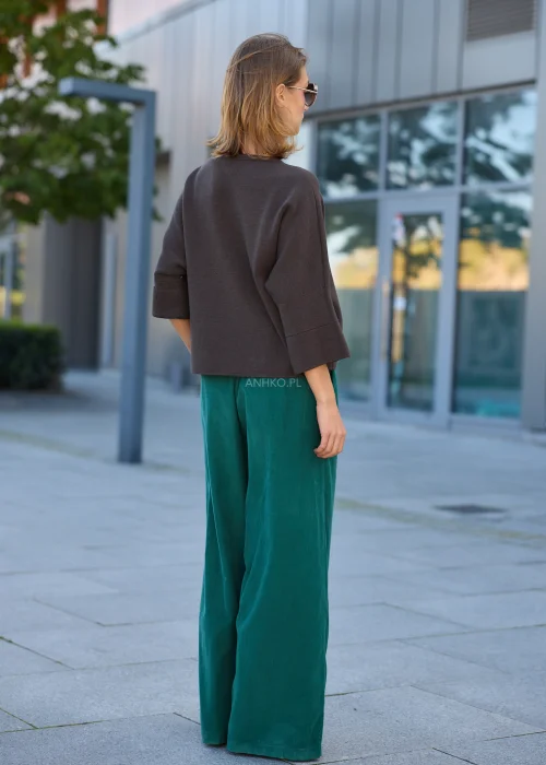 Dzianinowy sweter damski oversize w ciemnobrązowym kolorze, z szerokim fasonem, obniżoną linią ramion i luźnymi rękawami o długości 3/4.