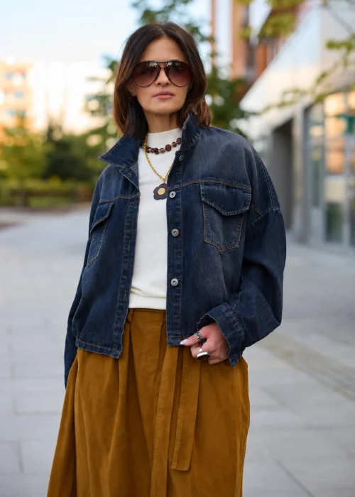 Krótka kurtka jeansowa oversize z obniżoną linią ramion i elastycznym wykończeniem u dołu. Stylowy fason z dużymi kieszeniami i efektem spranego denimu świetnie uzupełnia codzienne stylizacje.