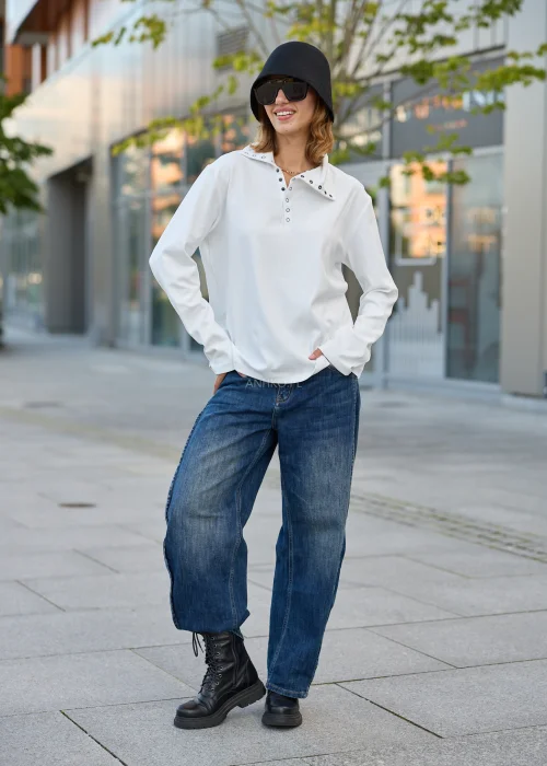 Bluzka damska oversize biała z szerokim kołnierzem, dekoracyjnymi napami i krótkim zapięciem przy dekolcie.