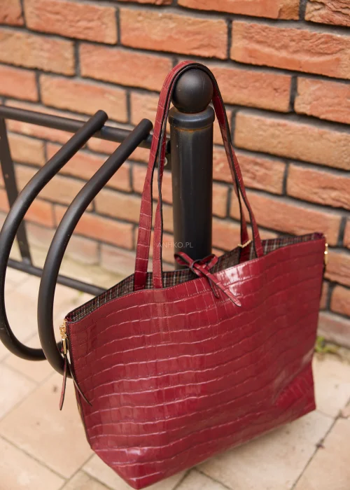 Duża torebka shopper damska w bordowym kolorze z tłoczeniem imitującym skórę krokodyla, wyposażona w dopasowaną kosmetyczkę i złote detale.