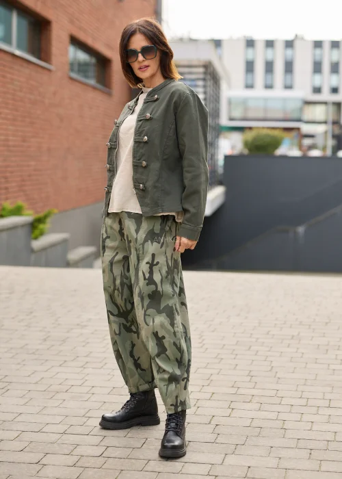 Spodnie damskie oversize w militarny wzór moro w odcieniach khaki i ciemnej zieleni, z szerokimi nogawkami o swobodnym fasonie.