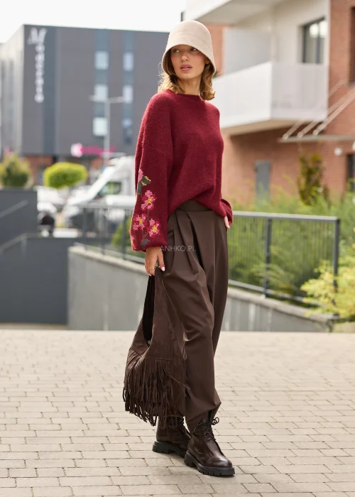 Sweter damski oversize w bordowym kolorze, z szerokimi rękawami ozdobionymi kolorowym haftem w kwiatowe motywy.