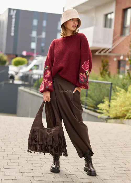 Sweter damski oversize w bordowym kolorze, z szerokimi rękawami ozdobionymi kolorowym haftem w kwiatowe motywy.