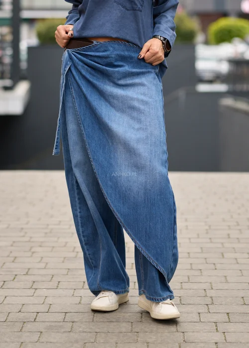 Jeansy damskie wide leg w niebieskim denimie, z asymetrycznym kopertowym przodem, wysokim stanem i szerokimi nogawkami.